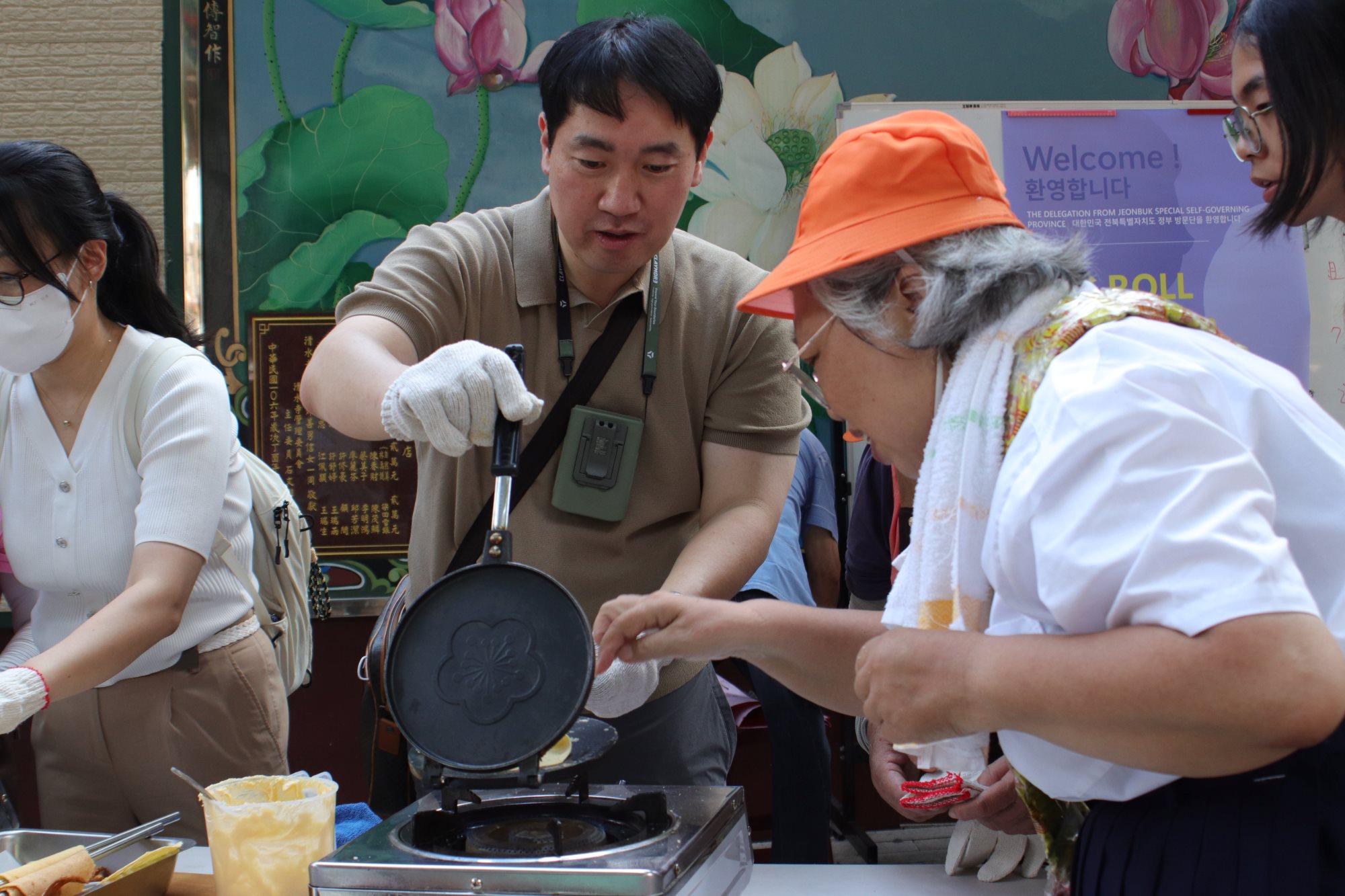 A delegation from Jeonbuk State, Korea, makes egg rolls with older residents of Yintong Community
